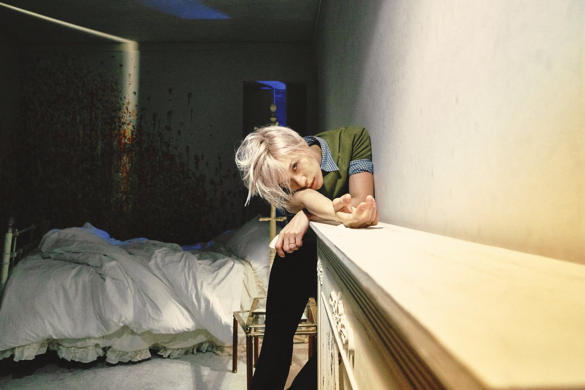 TAEMIN in a concept photo for the 2026 mini album PHASE 1 Soft Violence, resting his arms on a shelf and looking straight ahead