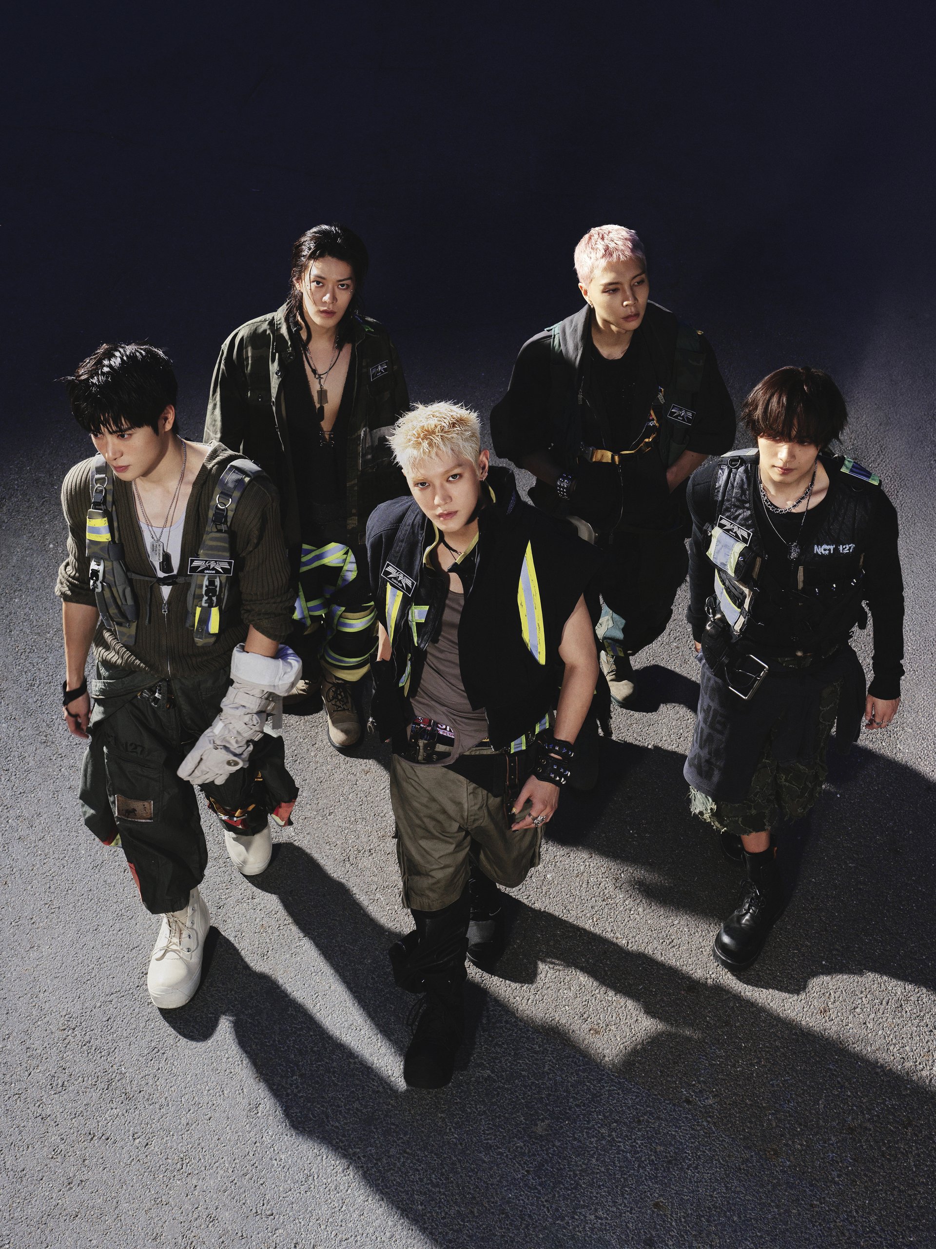 I cinque membri degli NCT 127 rivolti verso l'alto su sfondo scuro in una foto concept di BLINGY