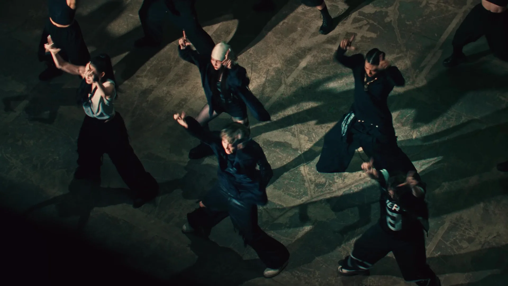 Overhead view of ALLDAY PROJECT's five members performing the same move on the basement set of the WICKED performance video